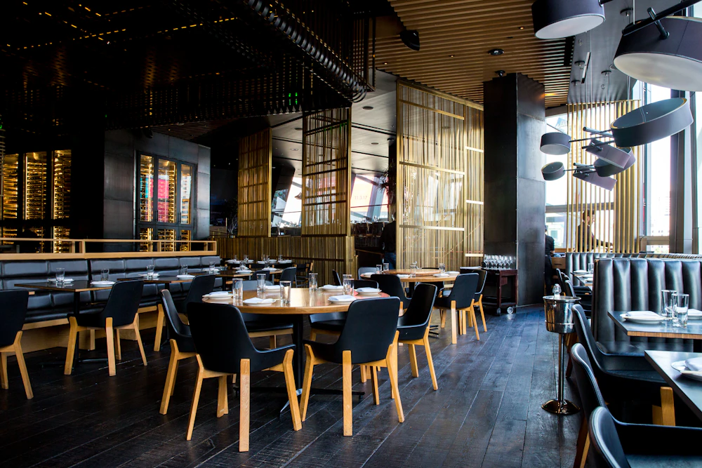 Luce calda e tavoli in legno nella sala dell’osteria